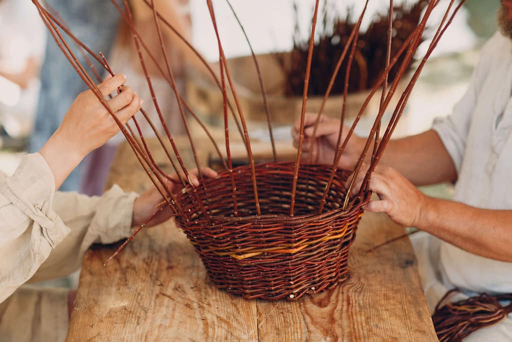 Master man weaves a basket of twigs