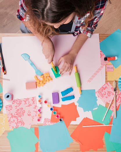 top-view-woman-cutting-colorful-clay-paper